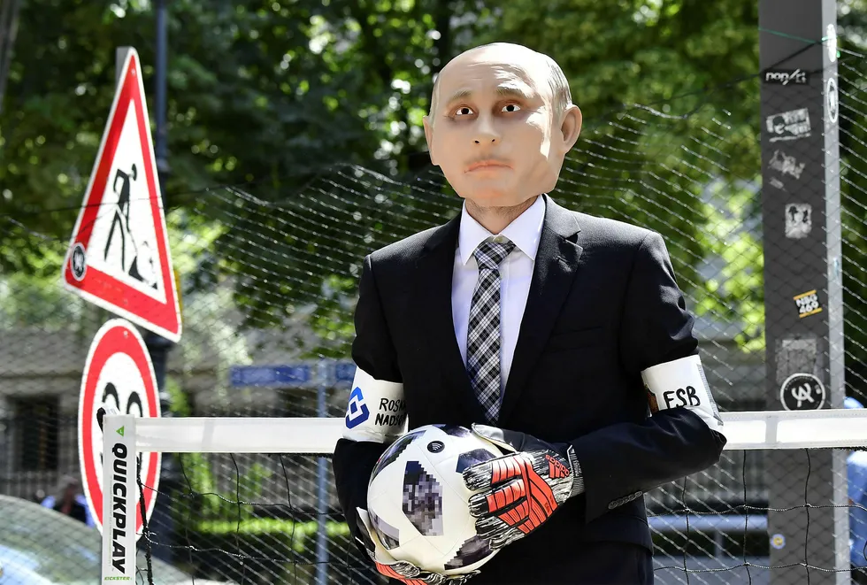 En demonstrant fra organisasjonen Reportere uten grenser har på seg en Vladimir Putin-maske foran den russiske ambassaden i Tyskland. Torsdag starter fotball-VM i Moskva. Foto: Tobias Schwarz/AFP/NTB Scanpix