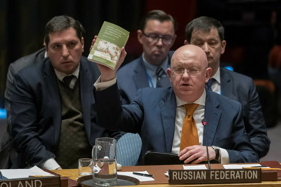 Russlands FN-ambassadør Vasilij Nebenzja holder opp et eksemplar av boken Alice i eventyrland mens han snakker i FNs sikkerhetsråd torsdag. Foto: Mary Altaffer/AP photo/NTB Scanpix