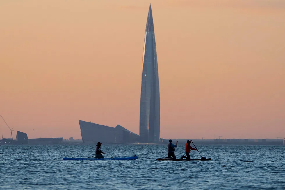 Rough water: people steer paddle boards at the Finnish Gulf coast, with headquarters of Russian gas monopoly Gazprom, Lakhta Centre, seen in background