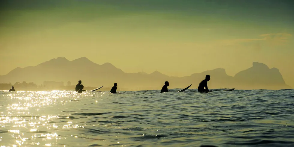 Surfers wait for waves at the Praia da Macumba beach in Rio de Janeiro