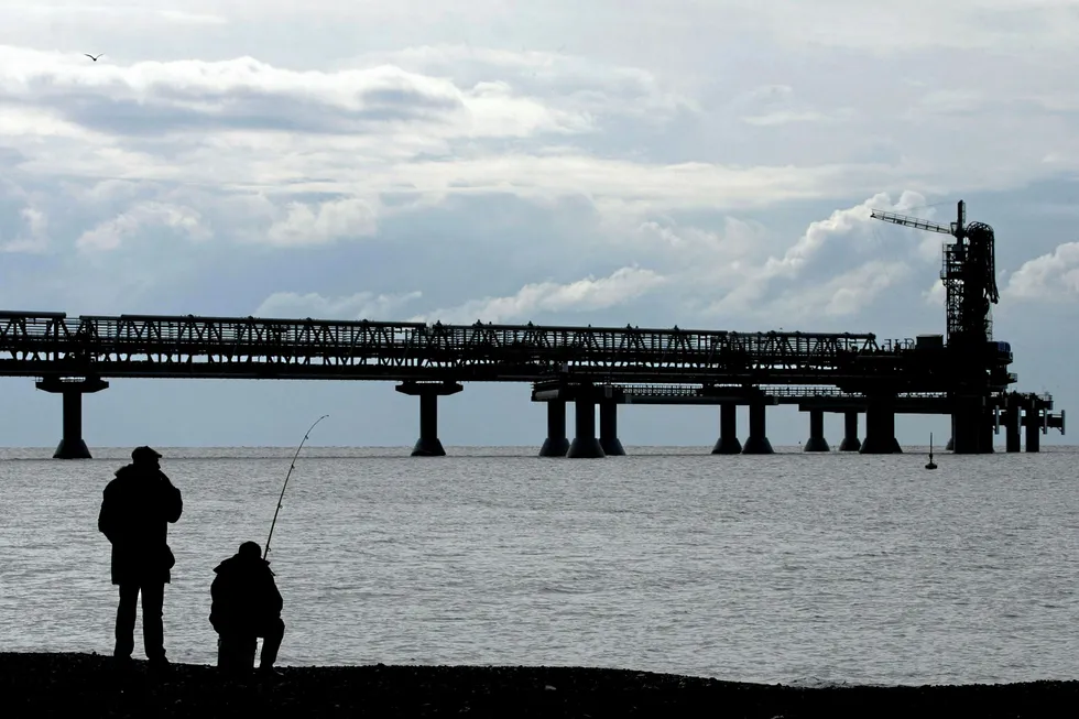 Third train on the cards: a man and a fisherman near the Sakhalin-2 project's liquefaction gas plant in Prigorodnoye, Russia