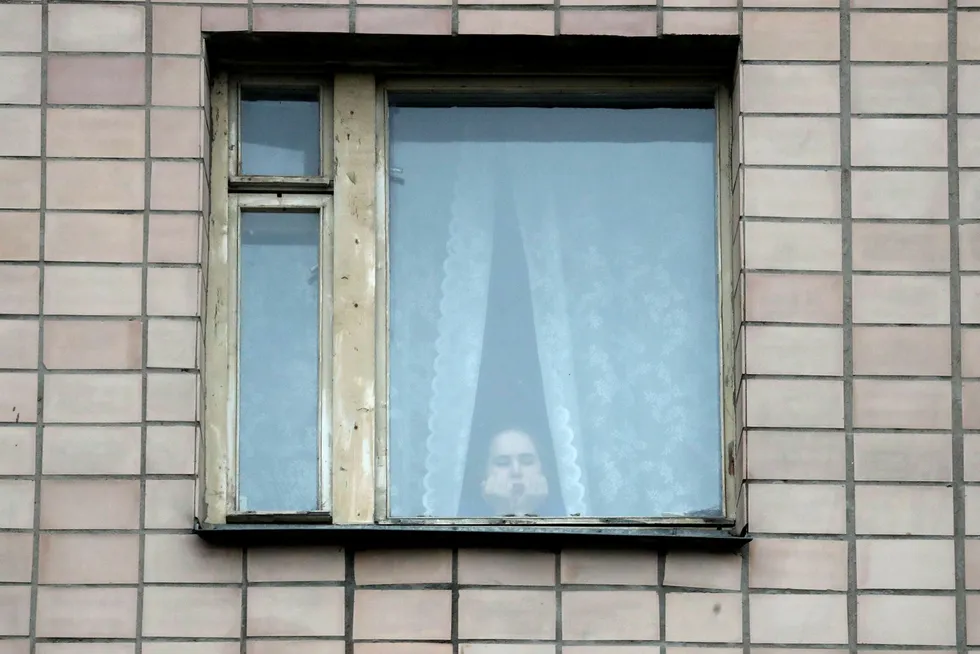 En ung kvinne sitter i korona-karantene i St. Petersburg. De kan blir mange de nærmeste ukene.