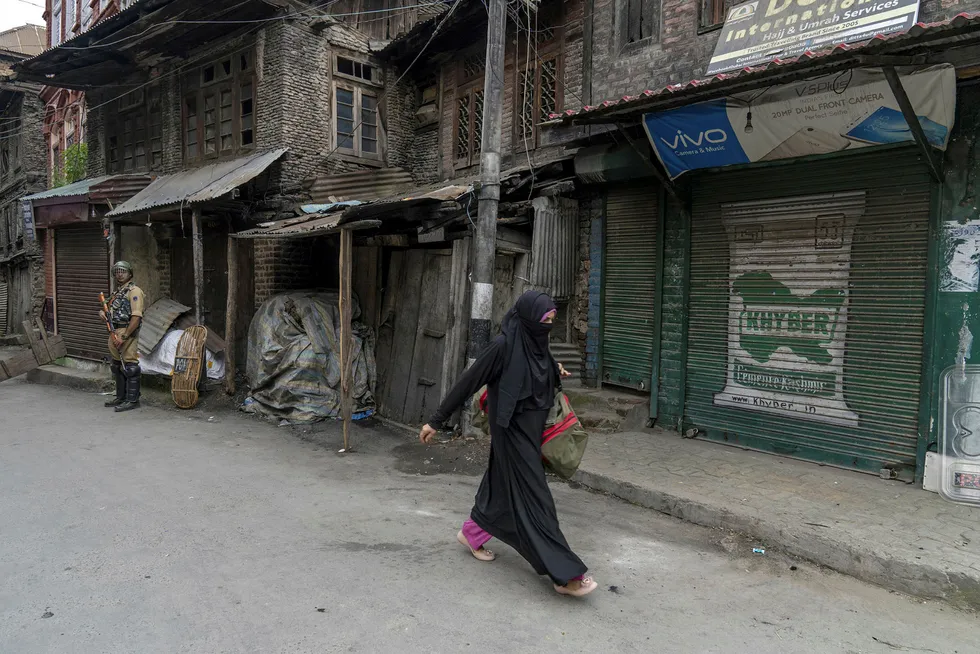 A pedestrian walks past a member of the Indian security forces in the Old Town of Srinagar, Jammu and Kashmir, India, on Friday, Aug. 30, 2019. Heavily armed soldiers line the quiet streets, where traders and shopkeepers have shut their businesses in protest. It's been like this since Aug. 5, the day Indian Prime Minister Narendra Modi's government revoked almost seven decades of autonomy held by the restive state of Jammu and Kashmir. Photographer: Sumit Dayal/Bloomberg