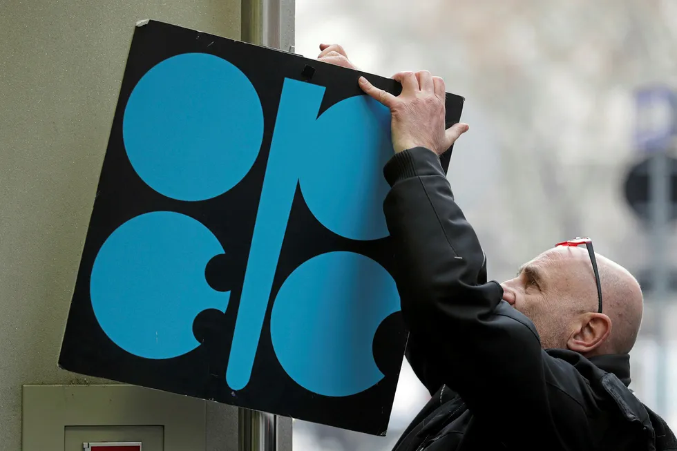 Sign of the times: a man fixes a sign with the Opec logo next to the group's headquarter's in Vienna