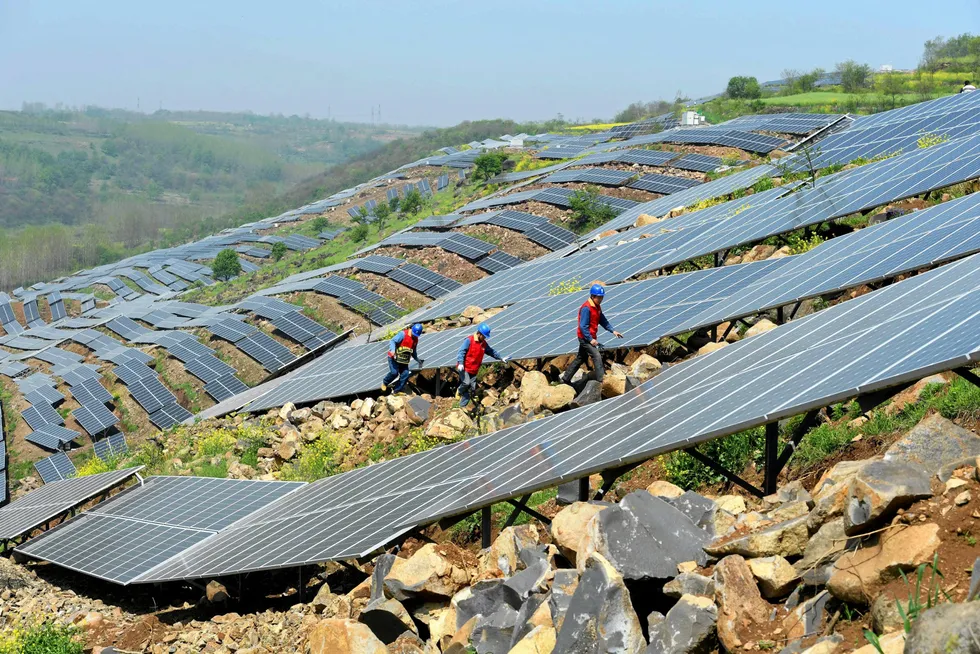 Increasing capacity: Chinese workers check solar photovoltaic modules on a hillside in a village in Chuzhou, in eastern China's Anhui province