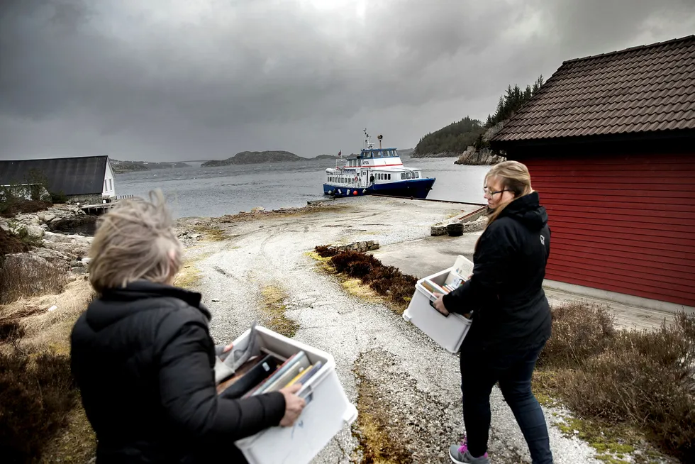 Tung litteratur. Vivi Haraldseid fra øya Drønen får hjelp av datteren Hilde Haraldseid til å bære en kasse ferdigleste bøker ombord i bokbåten, som ligger til kai ved Rostøy.