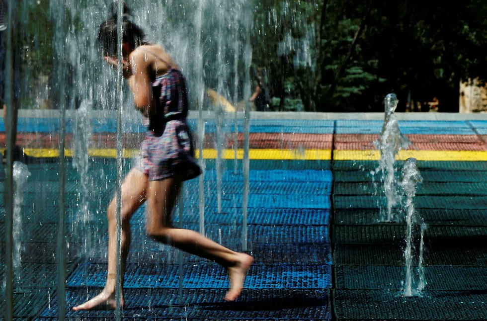 En jente løper gjennom en fontene i Tbilisi i Georgia. Foto: David Mdzinarishvili/Reuters/NTB Scanpix