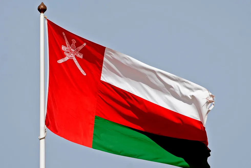 Award: the Omani national flag waving in the wind in the capital Muscat