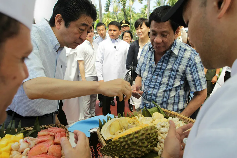 Japans statsminister Shinzo Abe (til venstre) spiste durian sammen med Filippinenes president Rodrigo Duterte tidligere i januar. Den japanske staten stiller med finansiering til større infrastrukturprosjekter på Filippinene og selskaper fra hele verden flokker til landet for å delta i en høy økonomisk vekst. Foto: Simeon Celi/AFP/NTB Scanpix