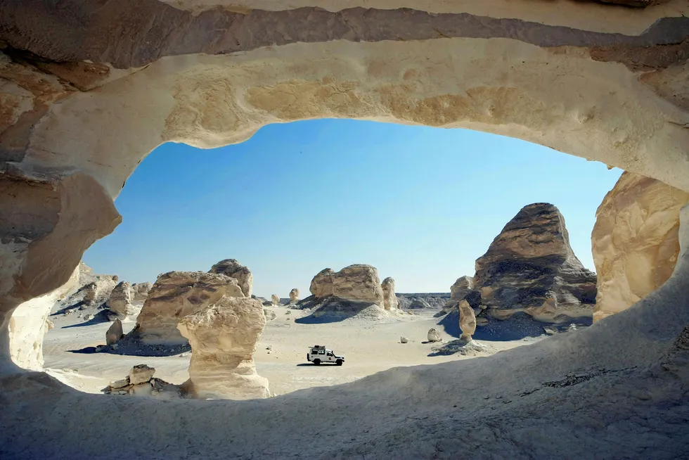 Off road: a vehicle moves among chalk inselbergs in Egypt's Western Desert