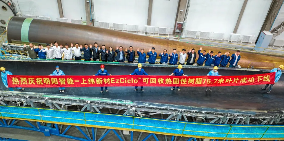Workers posed beside Mingyang Smart Energy's first recycled wind turbine blade