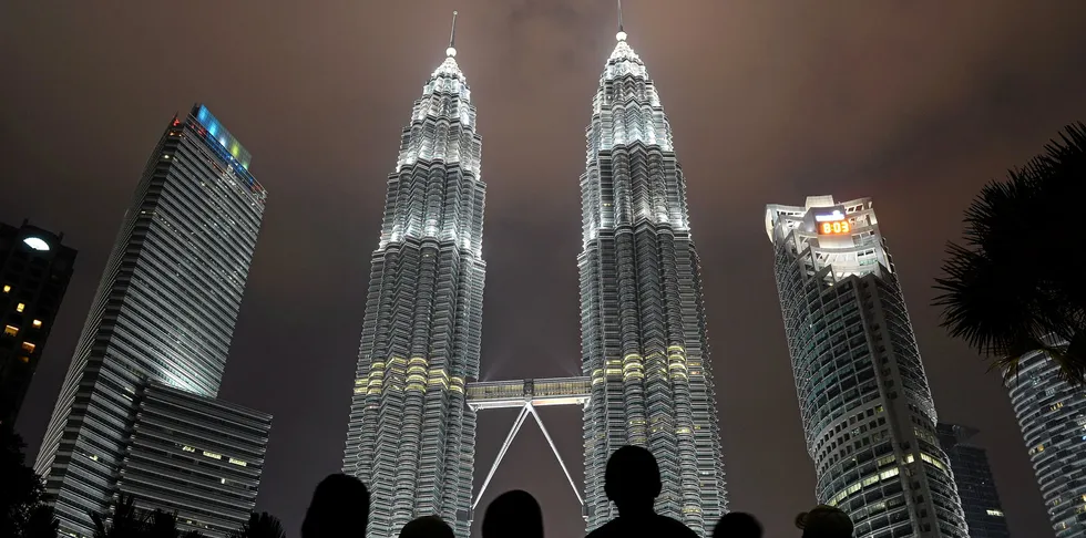 People stand in front of Malaysia's landmark Petronas Twin Towers. The Malaysian group is being tipped as a big force in Asian floating wind.