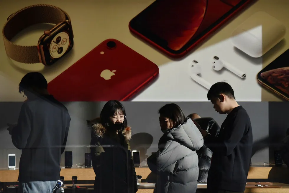 Kunder ser på produkter i en Apple-butikk i Beijing i desember i fjor. At Apple sliter med å få solgt produkter til kineserne, er noe flere tolker som at kinesere er i ferd med å få kjøpekraften sin svekket.