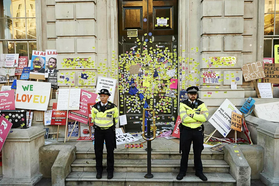 Politi vokter inngangen til statsministerens kontor etter en demonstrasjonsmarsj i helgen hvor demonstranter hadde satt igjen plakater og stickers foran kontoret. Lørdag marsjerte 700.000 mennesker gjennom London med krav om en folkeavstemning om den endelige skilsmisseavtalen med EU.