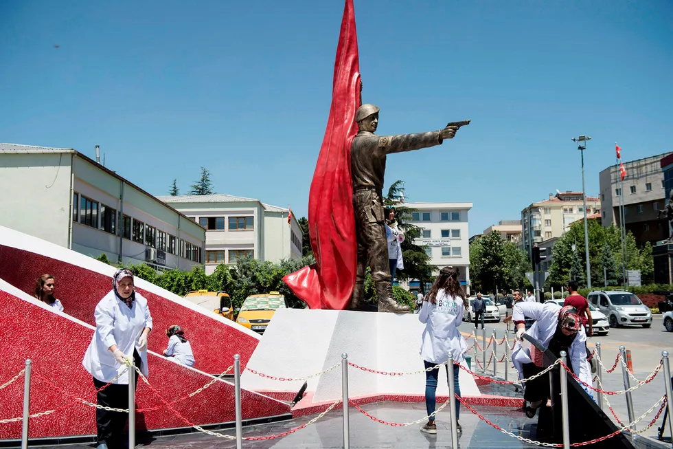 Kommuneansatte vasker statuen av sersjant Omer Halisdemir som ble drept i kuppforsøket 15. juli i fjor. Folk valfarter til den lille landsbyen Nigde i Tyrkia for å hedre Halisdemir for hans innsats i å forsøket på å avsette president Recep Tayyip Erdogan. Foto: Yasin Akgul/AFP/NTB Scanpix