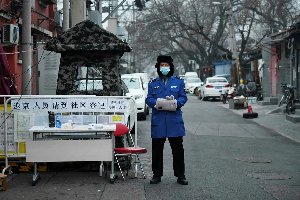 En sikkerhetsvakt med ansiktsmaske for å beskytte seg mot Covid-19 koronaviruset ved et checkpoint i Beijing. Myndighetene mener nå å ha fått kontroll på epidemien.