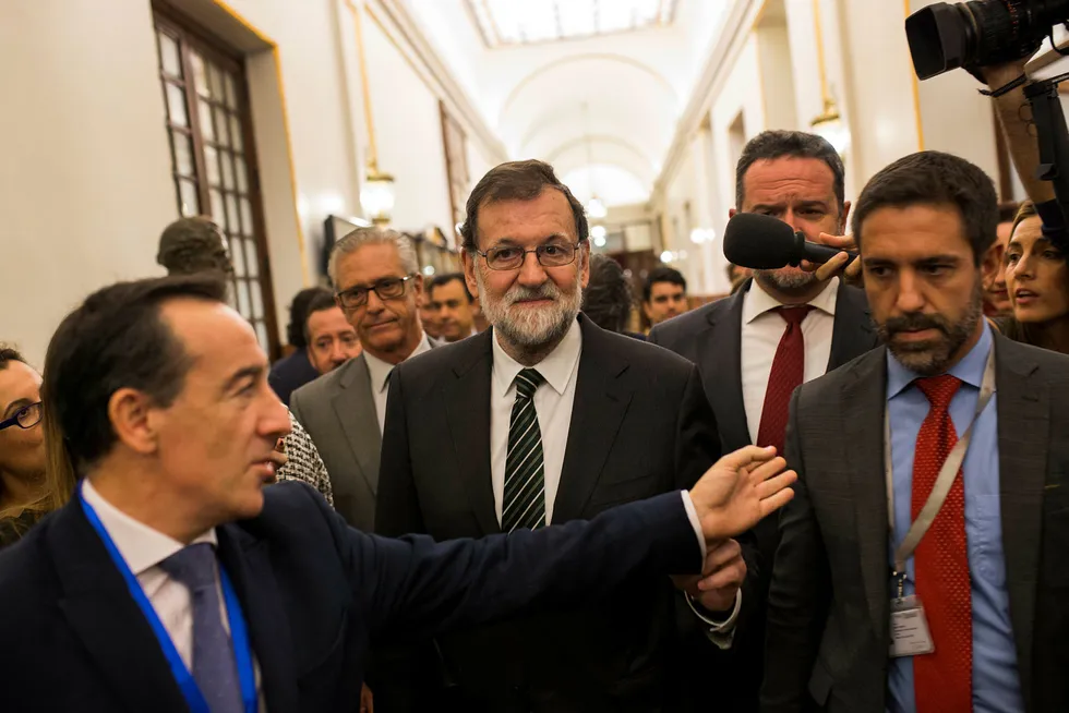 Spanias statsminister Mariano Rajoy (i midten) blir intervjuet av journalister mens han forlater den spanske parlamentet onsdag. Foto: Francisco Seco/ AP