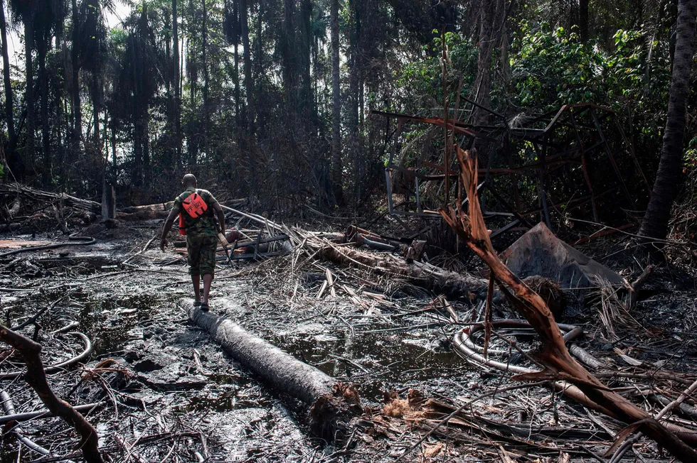 Polluted: A member of Nigeria’s navy walks through the site of a destroyed illegal oil refinery in the Niger Delta near Port Harcourt.