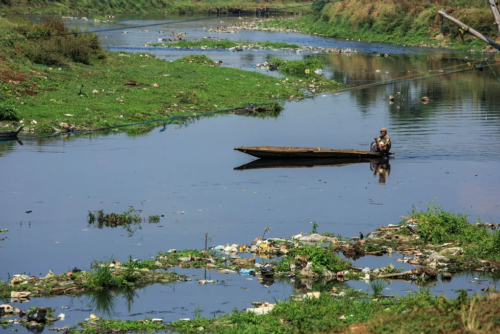 Store mengder søppel skjemmer det som kunne vært idylliske omgivelser for mannen i båten på Citarum-elven utenfor Bandung.