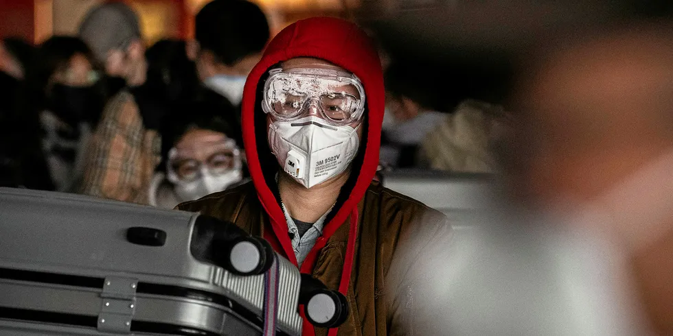 A man wears a protective mask and goggles as he lines up to check in to a flight at Beijing Capital Airport on January 30, 2020 in Beijing, China.