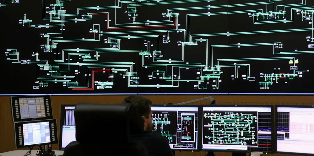 A technician monitors electricity levels in front of a giant screen showing the eastern German electricity transmission grid in the control center of grid operator 50 Hertz.