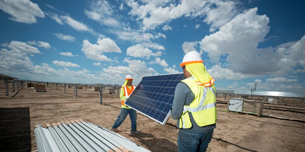 Workers install solar panels in the US for Swinerton