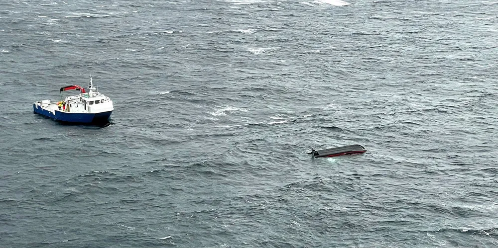 Dette bildet er tatt under redningsaksjonen i Hjeltefjorden forrige onsdag, og viser havaristen samt ett av fartøyene som bisto i redningsaksjonen