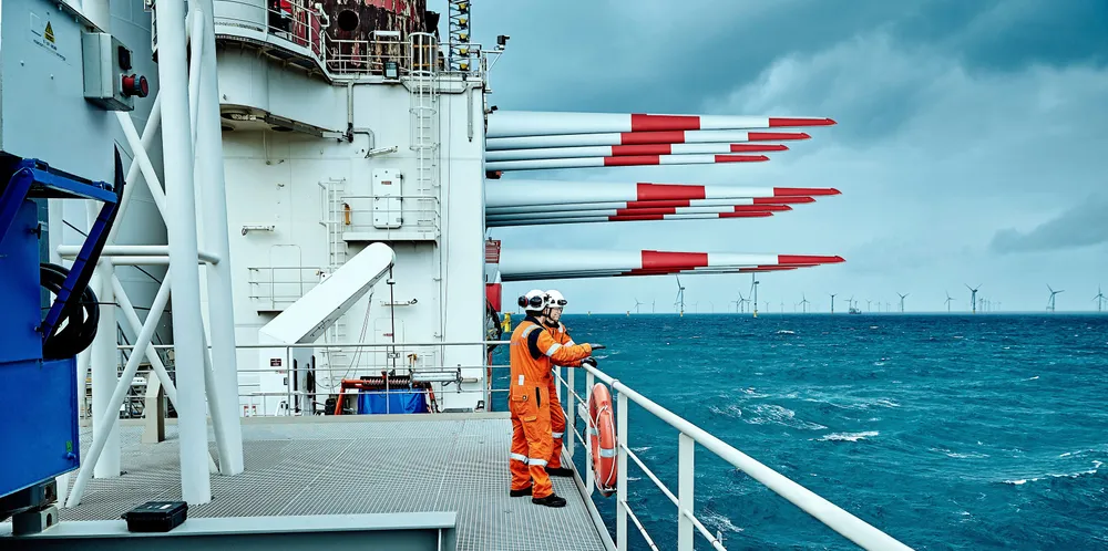 Crew on the deck of the component-laden Fred Olsen Windcarrier Brave Tern wind turbine installation vessel