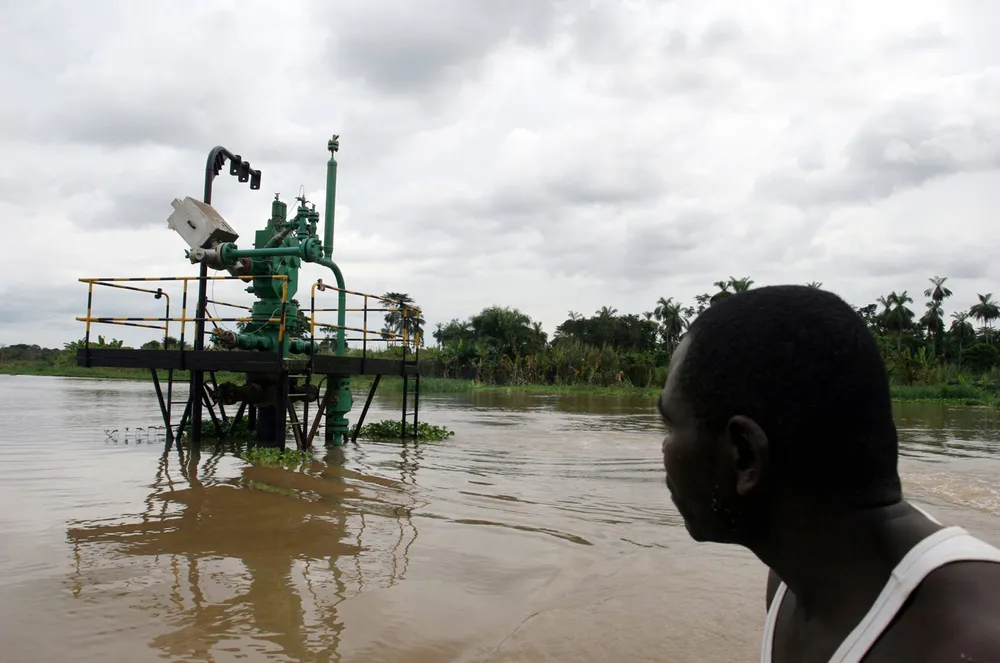 Deep in the Delta: a man passes a wellhead in the Delta
