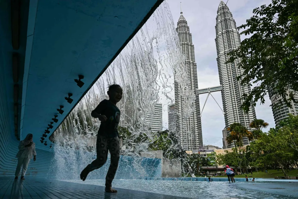 Play time at a public pool in front of Petronas' Twin Towers in Kuala Lumpur.