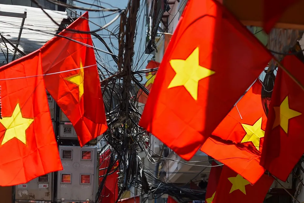 Advancing: a woman rides a bicycle along an alleyway in the capital Hanoi ahead of Vietnam's National Day celebration