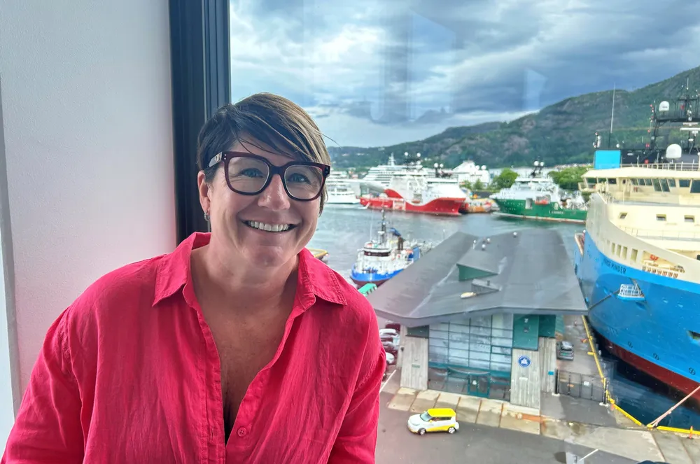 Siri-Anne Mjåtvedt i kontorvinduet. Skipene hun ser nede i Vågen i Bergen er langt fra så store som de hun bestyrer som toppleder i Utkilen rederi.