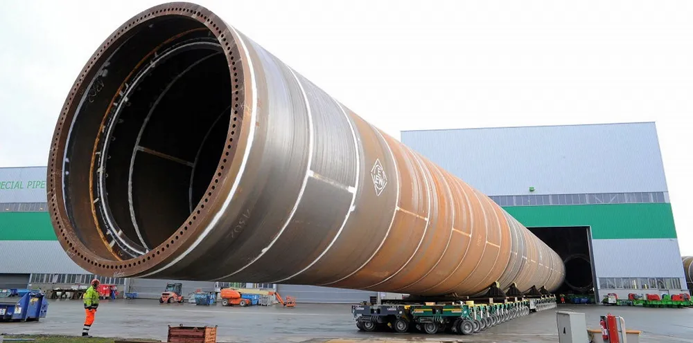 Giant XXL monopile being moved out of EEW production hall in Rostock, Germany