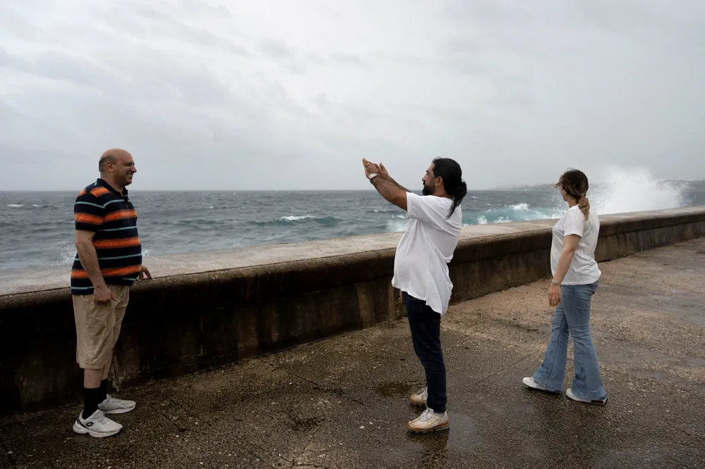 Tourists from Iran take pictures at the seafront Malecon as Hurricane Rafael approaches Havana, Cuba, on Wednesday, 6 November 2024.