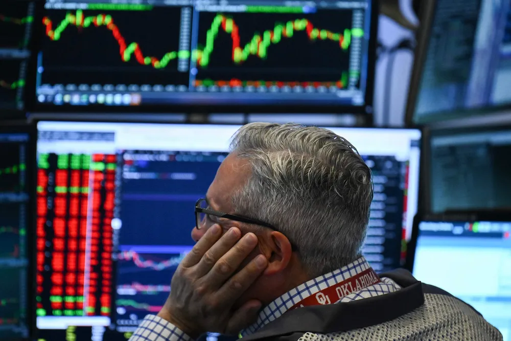 A trader works on the floor of the New York Stock Exchange (NYSE) at the opening bell on Friday, 13 June 2025, in New York City.