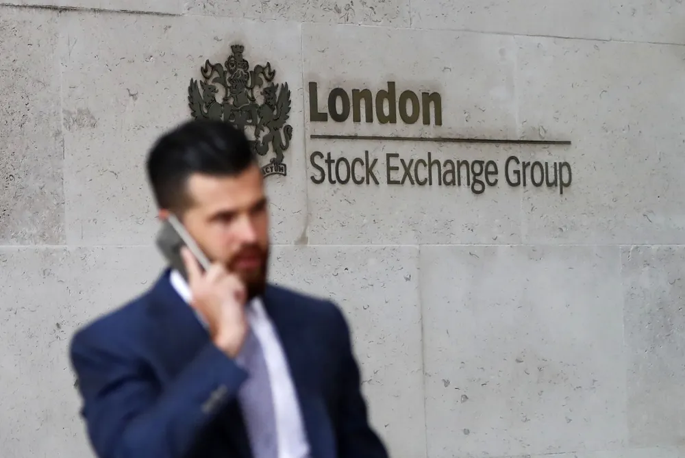 Commuters walk past the London Stock Exchange in the City of London.