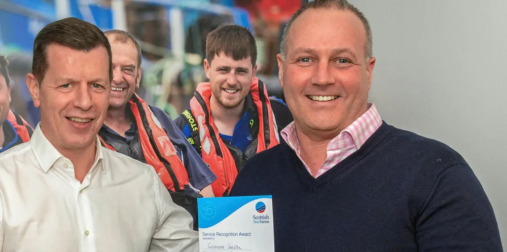 Scottish Sea Farms’ Managing Director Jim Gallagher (left) presenting Regional Production Manager for Shetland Graham Smith (right) with his 15-year certificate in 2019.