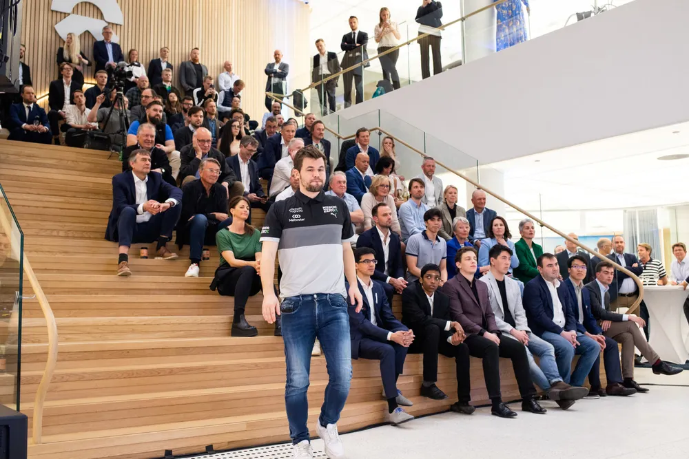 Play Magnus åpner Oslo Esports Cup lokalene til den kinesiske elbilprodusenten Nio på Karl Johans Gate. Til høyre for Magnus Carlsen (stående) sitter konkurrentene Anish Giri, Rameshbabu Praggnanandhaa, Jan-Krzysztof Duda, Eric Hansen, Shakhriyar Mamedyarov, Le Quang Liem og Jorden Van Foreest.