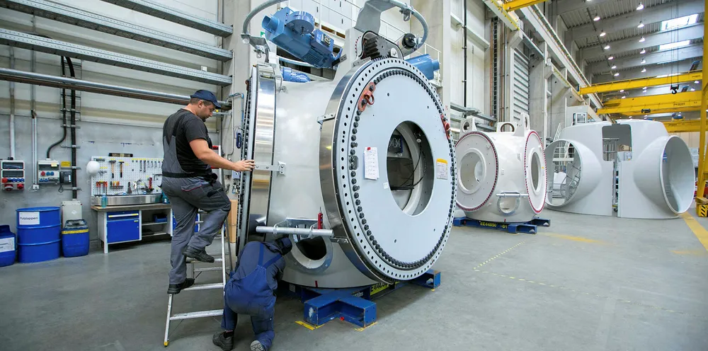 Employees assemble a wind turbine hub on a production line in Germany.