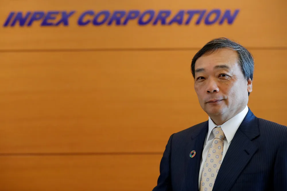 Inpex chief executive, Takayuki Ueda, poses in front of his company's logo.
