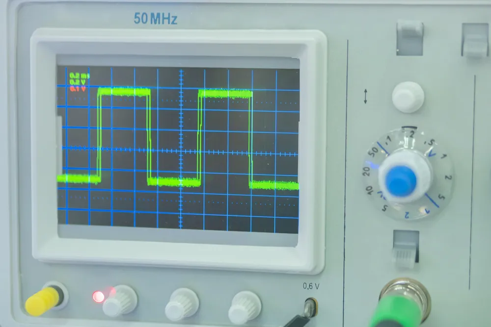 An oscilloscope showing the wave form of pulsed voltage.