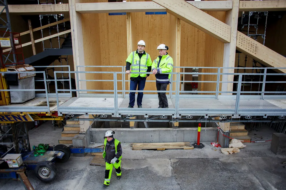 – Vi leverer massivtre i heissjaktene og til trappene. Heissjaktene i Mjøstårnet har en høyde på 76 meter, sier daglig leder Terje Strand i Woodcon til høyre med ryggen til heissjakten. Ved hans side står prosjektsjef Kent Are Kristiansen i Woodcon. Foto: Javad Parsa