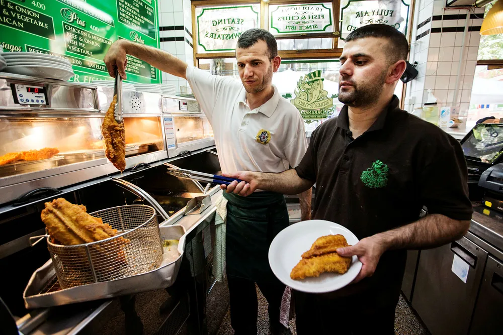 Norsk fish’n’chips servert ved Rock & Sole Place i Covent Garden i London. Vini Grollaku tar opp norsk torsk fra frityrstekeren med Esmar Fezulla. Foto: Jeff Gilbert