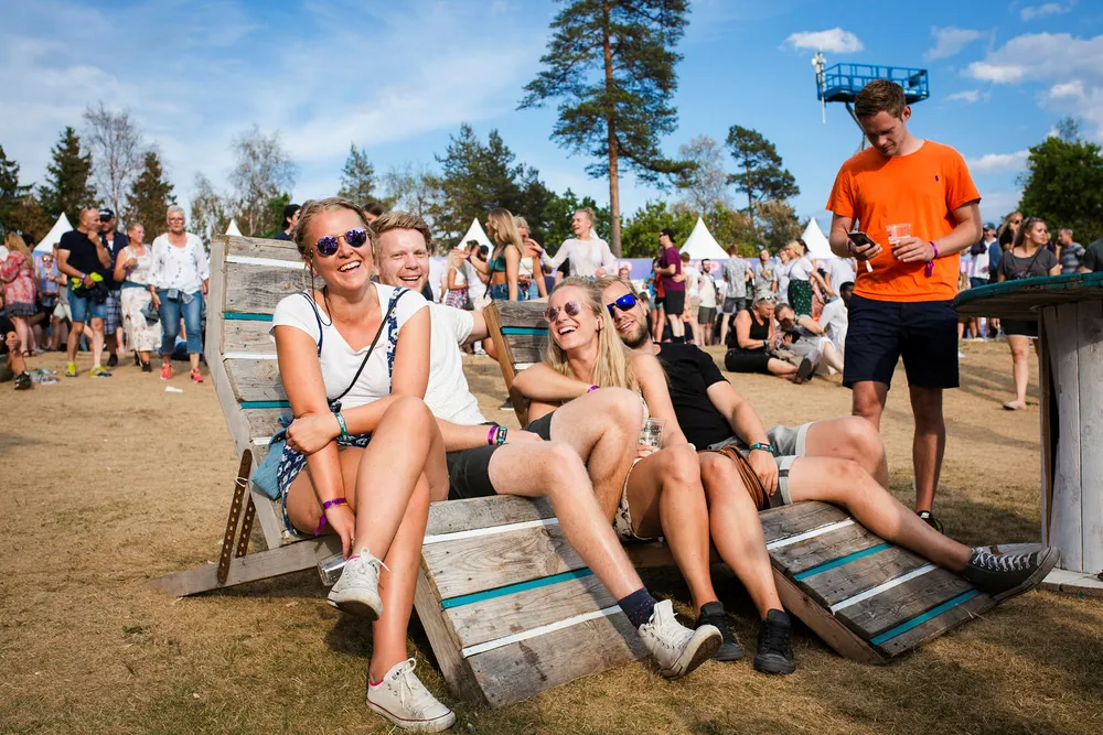 – Jeg tror ikke nødvendigvis jeg kommer til å bytte bank, sier Frida Hals (24) (til venstre), men legger også til at merkevarer som er til stede på festivaler fremstår hippe. Sammen med Kristian Andresen (26), Ida Steffens (26) og Fredrik Torgersen (27) besøker hun Stavernfestivalen og benytter seg av sponsoren DNBs stoler. Foto: Sebastian S. Bjerkvik