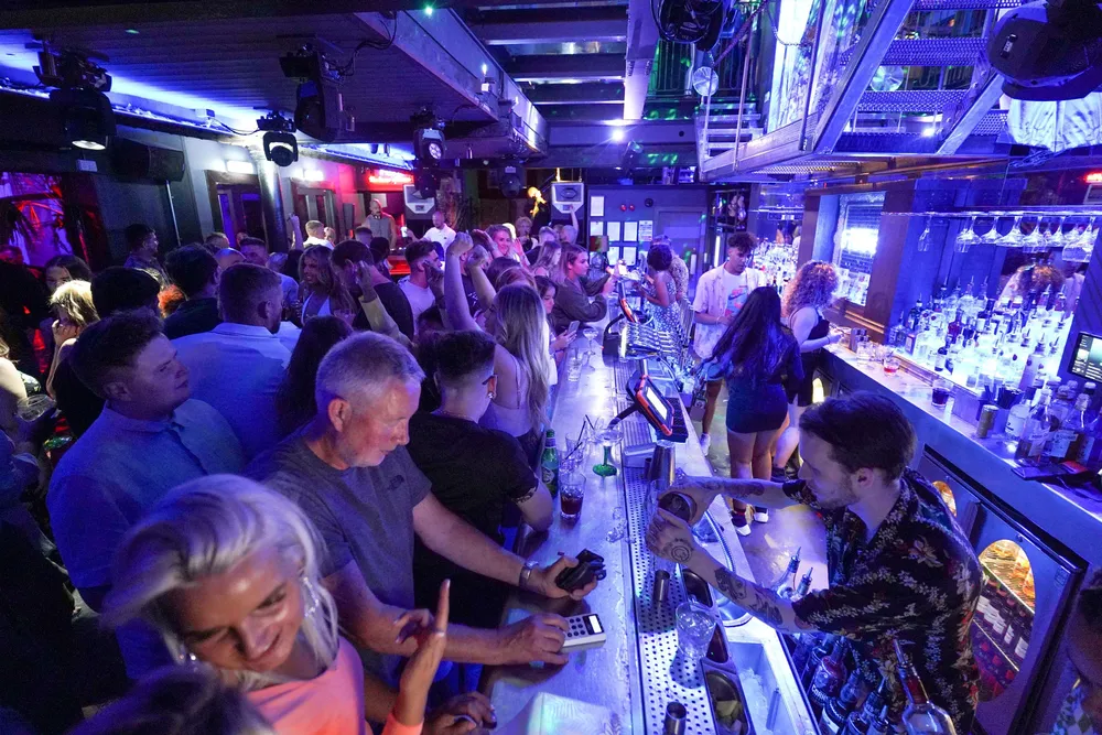 Folk samles på Bar Fiber i Leeds, etter at smittevernsrestriksjonene ble opphevet i England ved midnatt, mandag 19. juli