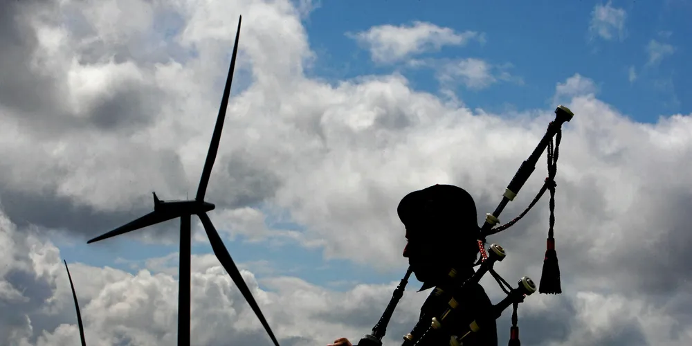 A piper plays at the Whiteless wind farm in Scotland