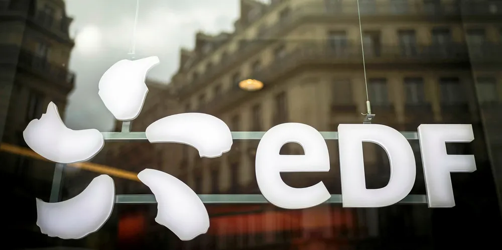 The logo of French electric utility company Electricite de France (EDF) is pictured as buildings reflect on a window in Paris.