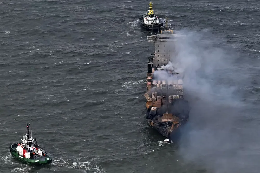 Smoke rises from the deck of the Solong as tugs stand off in the North Sea on Tuesday following Monday's collision.