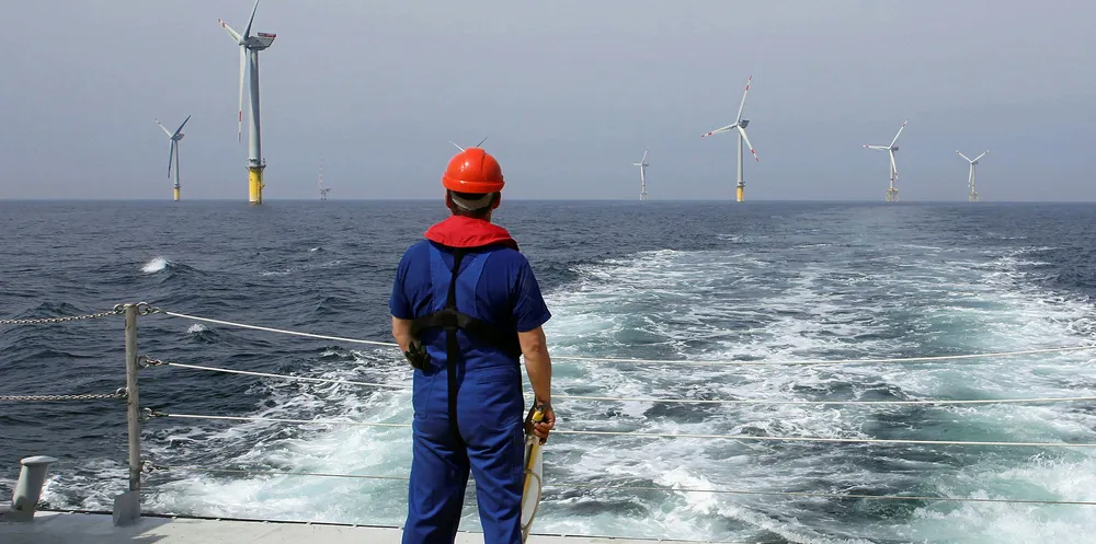 A worker looks out at wind turbines at the Alpha Ventus offshore wind farm of the German coast