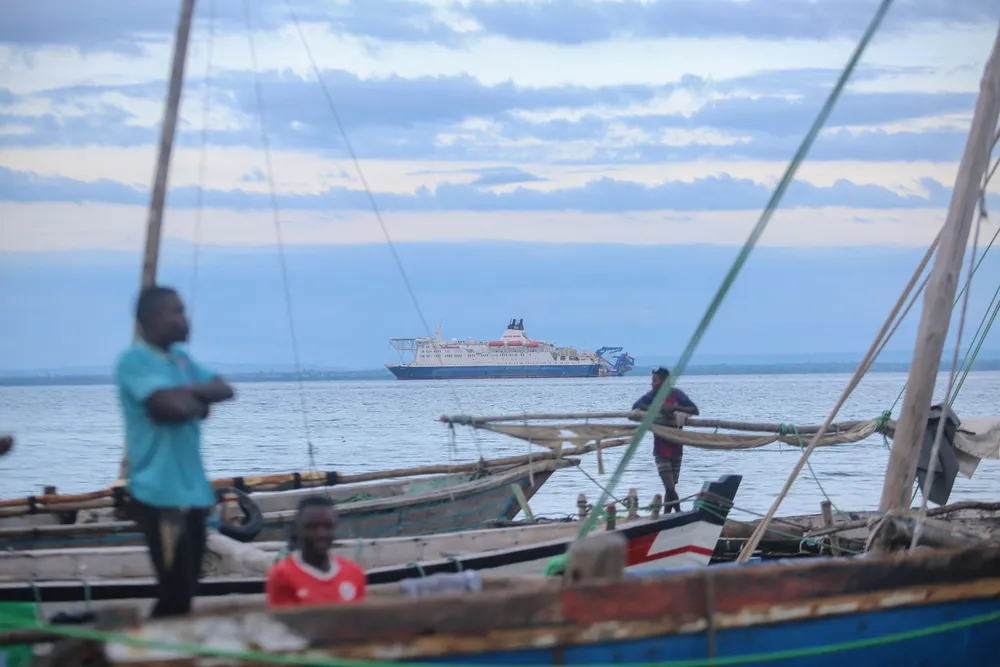 Fishermen wait at their boats at the port of Paquitequete near Pemba on 29 March 2021. Sailing boats are expected to arrive with people displaced from the coasts of Palma and Afungi after suffering attacks by armed groups